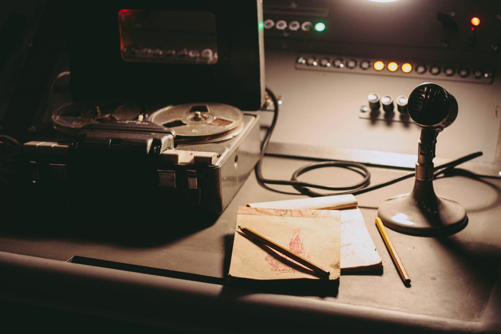 A record player, tape recorder, scissors, and print materials arranged on a worktable.