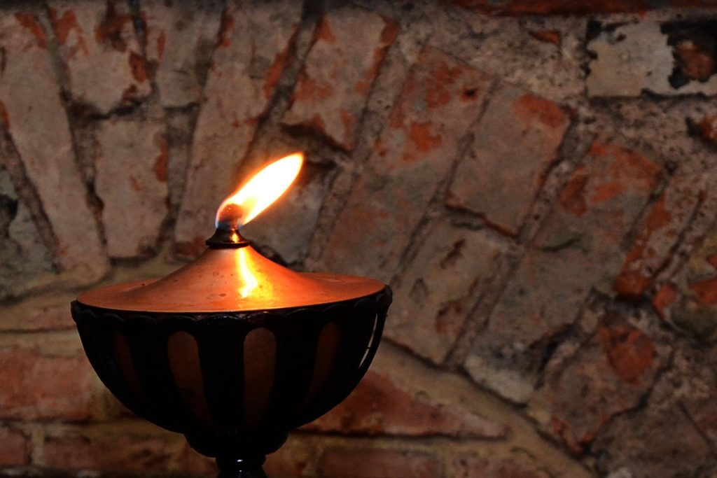An old oil lamp glowing in darkness