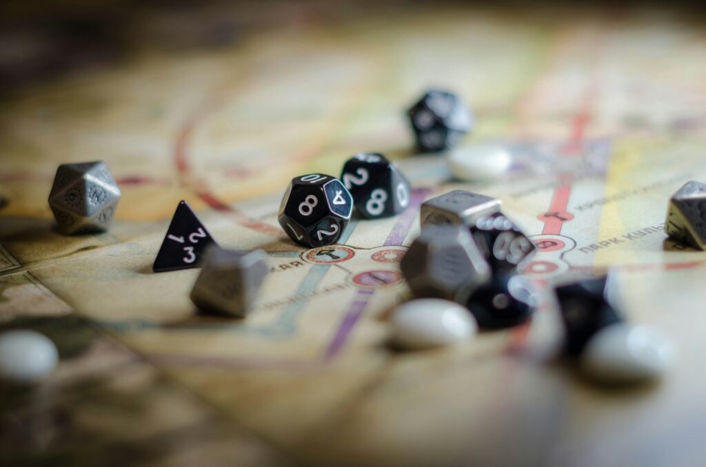 Black and white polyhedral dice scattered across a dark wooden table