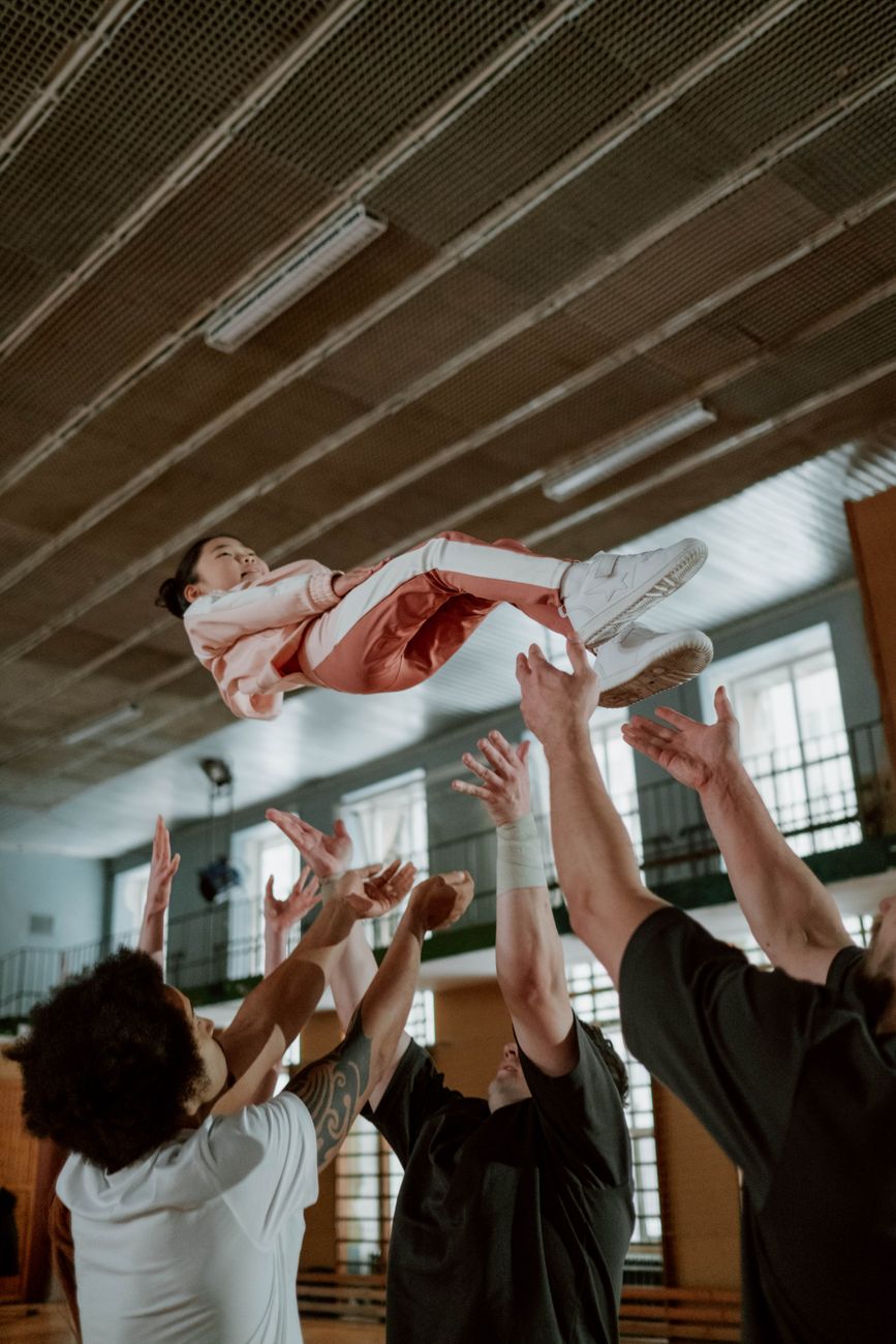 people throwing up a girl in the air